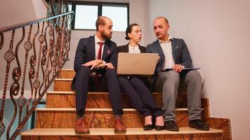 Businesswoman talking with company manager and office executive on staircase of business building. Professional entrepreneur in team work with coworker on office stairs using the laptop and tablet. photo