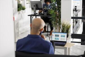 Financial analyst using laptop to research and plan budget for company project in business office. Corporate worker monitoring stock exchange data for investment strategy photo