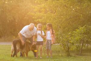 Grandfather And Granddaughters Taking Dog For Walk photo