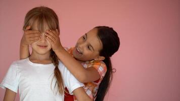 Portrait of two nice-looking attractive charming cute lovely friendly cheerful pre-teen girls isolated on pink pastel background photo