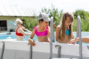 Kids in swimming pool. Girl swim outdoors. photo