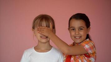 Portrait of two nice-looking attractive charming cute lovely friendly cheerful pre-teen girls isolated on pink pastel background photo