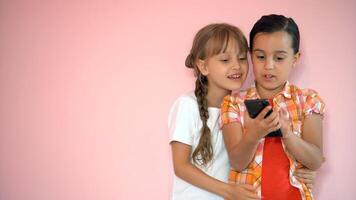 people, children, technology, friends and friendship concept - happy little girls with smartphones lying on floor at home photo