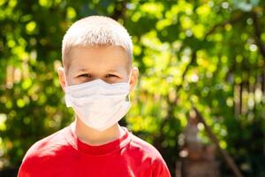 preteen boy in protection mask on the highway city background photo