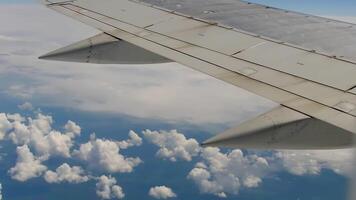 nuvens debaixo a asa do a aeronaves. Visão Fora do a avião janela em nuvens de luz solar video