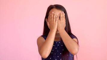 Girl playing hide and seek portrait. Cute little girl open her face with hands. Playing hide and seek photo
