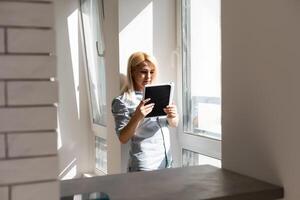 woman using tablet with sunbeams and lens flare photo