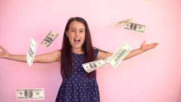 Cute little girl holding dollars, isolated over pink photo