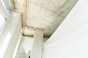 repairmen install stretch ceiling made of pvc vinyl film using a gas heat gun photo