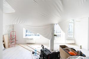repairmen install stretch ceiling made of pvc vinyl film using a gas heat gun photo