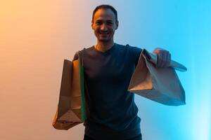 Delivery man hold craft paper packet with food on a blue background. Portrait of handsome man delivery food photo
