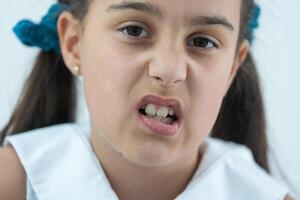 adulto permanente dientes viniendo en frente de el niño bebé dientes. tiburón dientes. pequeño muchachas abierto boca. consulta de dentista. problema. foto