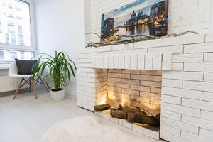 Fireplace on white brick wall in bright empty living room interior of house. photo