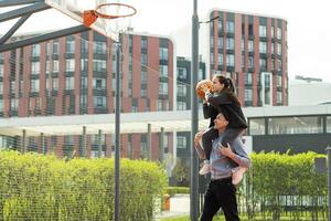 padre y Adolescente hija jugando baloncesto fuera de a Corte foto