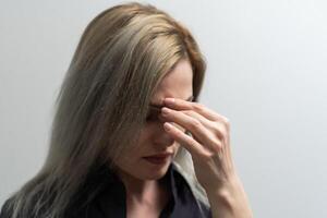 Young beautiful woman has headache isolated studio portrait. photo