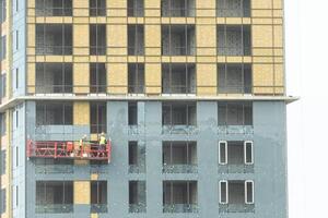 construcción cuna en un edificio a un altura con trabajadores trabajo a altura en un construcción cuna foto