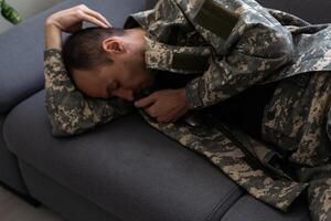 Thoughtful militaryoman is resting in a bright living room photo