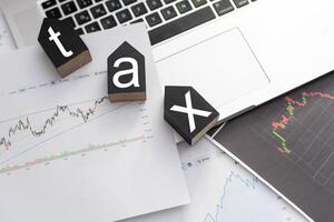 Tax Concept.Word tax and stacked coins put on desks photo