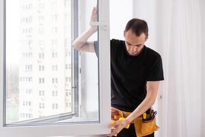 Construction worker installing new window in house photo