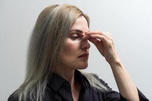 Young beautiful woman has headache, isolated on gray background photo