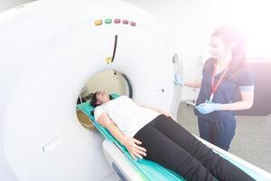 Radiologist with a female patient in the room of computed tomography. photo