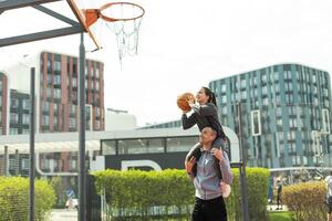 contento padre y adolescente hija fuera de a baloncesto corte. foto