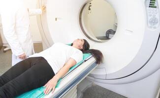 beautiful woman lying on ct scanner bed during tomography test in hospital photo