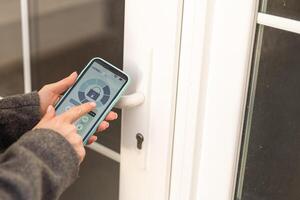 Smiling woman setting home security system with help of mobile application. photo