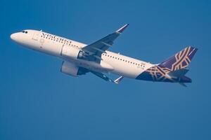 New Delhi, India, December 25 2023 - Vistara Airbus A320 neo take off from Indra Gandhi International Airport Delhi, Vistara domestic aeroplane flying in the blue sky during day time photo