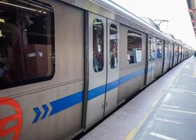 New Delhi, India, February 17 2024 - Delhi Metro train arriving at Jhandewalan metro station in New Delhi, India, Asia, Public Metro departing from Jhandewalan station photo