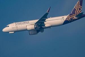 New Delhi, India, December 25 2023 - Vistara Airbus A320 neo take off from Indra Gandhi International Airport Delhi, Vistara domestic aeroplane flying in the blue sky during day time photo