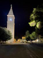 un alto blanco torre a noche foto