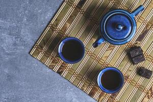 Tableware for tea ceremony top view. Blue tea set pottery on bamboo napkin. photo