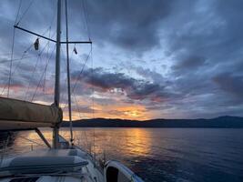 a sailboat is docked at sunset with clouds in the background photo