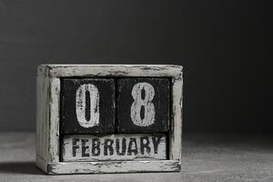 febrero 08 en de madera calendario, en oscuro gris antecedentes. foto