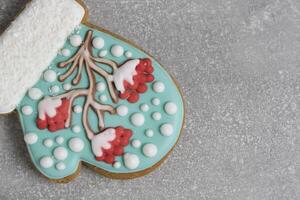 Christmas cookies in shape mitten, decorated with icing depicting rowan tree, sprinkled with snow. Magic holiday every sweet detail. photo