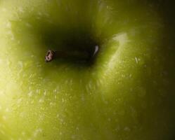 a close up of a green apple with water droplets photo
