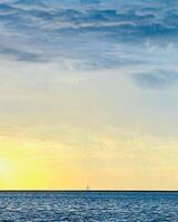 a sailboat is sailing in the ocean at sunset photo