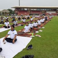 nuevo Delhi, India, junio 21, 2023 - grupo yoga ejercicio sesión para personas a yamuna Deportes complejo en Delhi en internacional yoga día, grande grupo de adultos asistiendo yoga clase en Grillo estadio foto