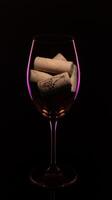 a glass of wine with corks in it photo