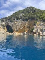 a cave in the water near a cliff photo