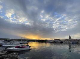 a cloudy sky with a few boats in the water photo