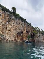 a boat is in the water near a cliff photo