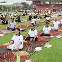 nuevo Delhi, India, junio 21, 2023 - grupo yoga ejercicio sesión para personas a yamuna Deportes complejo en Delhi en internacional yoga día, grande grupo de adultos asistiendo yoga clase en Grillo estadio foto