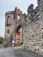 a stone wall with a gate and a clock tower photo