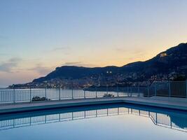 a pool in front of a mountain at dusk photo