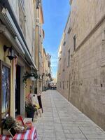 a narrow street with a table and chairs in it photo