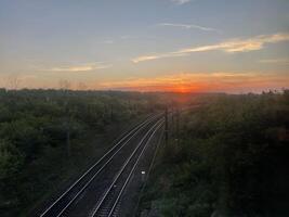 a train track with the sun setting behind it photo