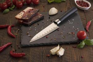 a knife and some meat on a cutting board photo