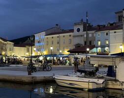 a harbor with boats and people at dusk photo